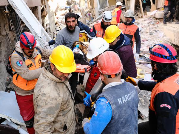 Helfer transportieren die gerettete Melda aus den Trümmern von Antakya.