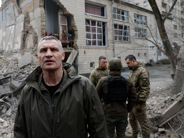 Klitschko, Bürgermeister von Kiew, schaut sich von russischen Attacken zerstörte Gebäude an. 