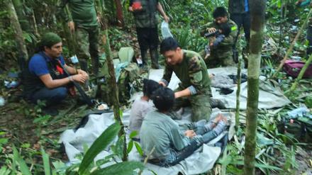Auf diesem von der Pressestelle der kolumbianischen Streitkräfte veröffentlichten Foto kümmern sich Soldaten und indigene Männer um die vier Geschwister, die nach einem tödlichen Flugzeugabsturz vermisst wurden, im Dschungel von Solano im kolumbianischen Bundesstaat Caqueta. 