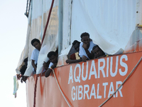 Aus Seenot gerettete Migranten blicken von dem Rettungsschiff "Aquarius" herunter.