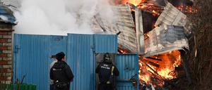 Nach einem Angriff kümmern sich Feuerwehrleute in Belgorod um den Brand eines Hauses.
