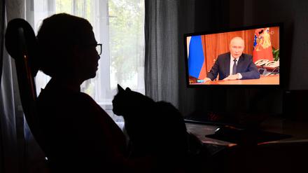 Eine Frau sieht im Fernsehen eine Ansprache des russischen Präsidenten Wladimir Putin an die Nation in Jekaterinburg.