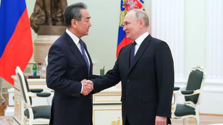 Der russische Präsident Wladimir Putin schüttelt die Hand des chinesischen Direktors der Zentralen Kommission für Auswärtige Angelegenheiten, Wang Yi, während ihres Treffens in Moskau.