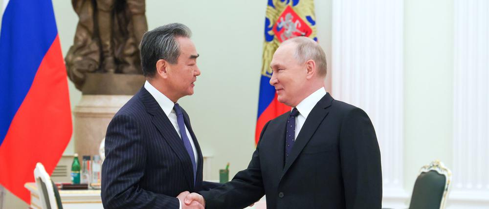 Der russische Präsident Wladimir Putin schüttelt die Hand des chinesischen Direktors der Zentralen Kommission für Auswärtige Angelegenheiten, Wang Yi, während ihres Treffens in Moskau.
