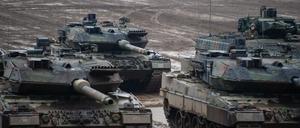 Drei Kampfpanzer der Bundeswehr vom Typ Leopard 2A6 und ein Schützenpanzer vom Typ Puma stehen bei einer Übung im Gelände. 