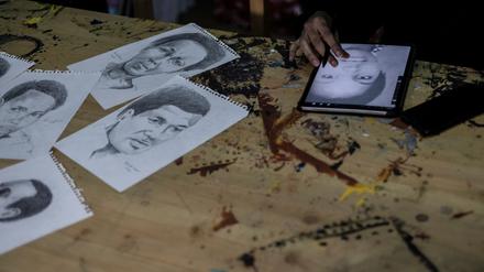 Ein Mitglied von „Art for Memories“ zeichnet das Porträt eines Opfers des ruandischen Völkermords.