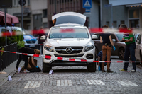 Mitarbeiter der Spurensicherung untersuchen den Tatort am weißen Mercedes-Geländewagen in Frankfurt am Main.