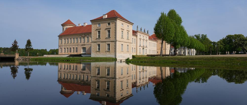 Die Parkseite von Schloss Rheinsberg mit dem Kurt Tucholsky Literaturmuseum spiegelt sich in dem vom Grienericksee gespeisten Wasser des Schlossgrabens.