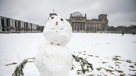 Vor dem Reichstagsgebäude steht ein Schneemann.