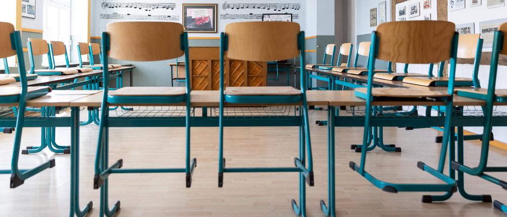 Schulklasse mit aufgestellten Stühlen.