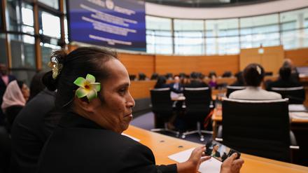 Eine Vertreterin mit Blume im Haar und weitere Vertreter, Anwälte und Anwältinnen einer Gruppe von neun kleinen Inselstaaten im Pazifik und in der Karibik sitzen im Gerichtssaal zu Beginn einer Sitzung des Internationalen Seegerichtshofs.