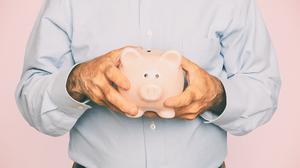 Senior man holding piggy bank for financial savings campaign