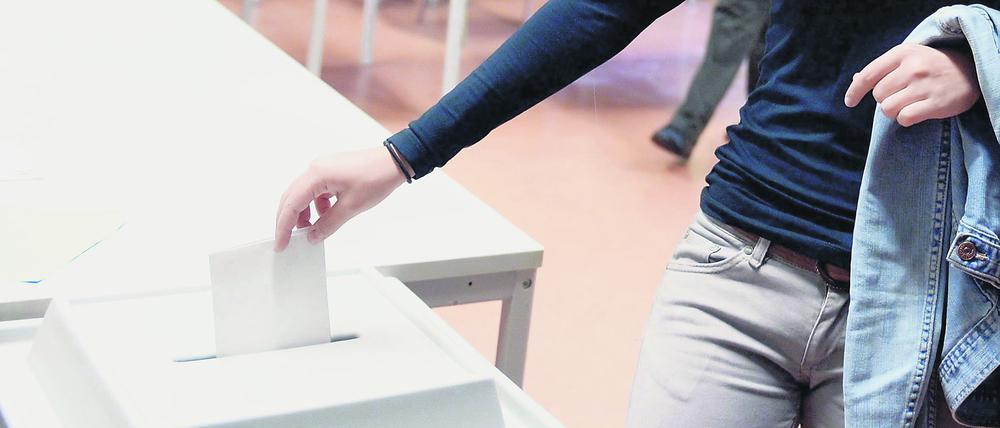 Junge Stimme: Eine Erstwählerin wirft einen Wahlzettel in eine Wahlurne.