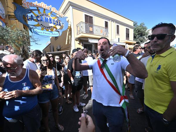 Der stellvertretende Bürgermeister von Lampedusa, Attilio Lucia (m), hat am Samstag zusammen mit hundert Bürgerinnen und Bürgern die Via Vittorio Emanuele blockiert und den Verkehr unterbrochen, um gegen die Migrationspolitik in Lampedusa zu protestieren.
