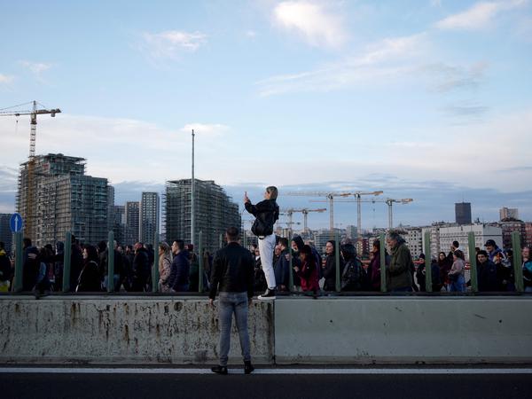 Eine Demonstrantin macht ein Foto während der Blockade einer Autobahnbrücke.