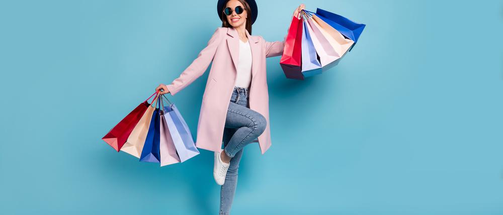 Full body photo of enthusiastic candid lady in eyewear, eyeglasses go shopping buy purchases wear pink coat denim jeans isolated over blue background