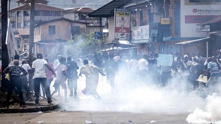 Supporters of the opposition party, All People's Congress (APC), run from teargas during a protest calling for the Chief electoral Commissioner, Mohamed Konneh, to step down after allegations of electoral fraud in Freetown on June 21, 2023. When Sierra Leoneans go to the polls in Saturday's presidential election, he plans to vote for the opposition All People's Congress (APC) party. Last time, he voted for incumbent President Julius Maada Bio of the Sierra Leone People's Party (SLPP) who is running again. (Photo by JOHN WESSELS / AFP)