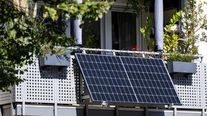 Am Balkon eines Mehrparteienhauses ist ein sogenanntes Balkonkraftwerk mit Solarzellen angebracht.