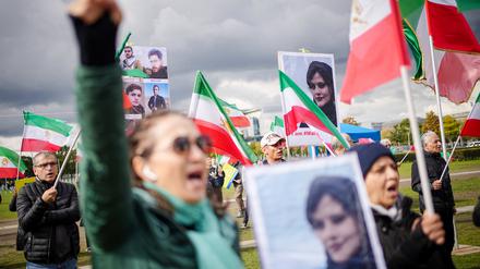 Mit Plakaten von Masha Amini demonstrieren Teilnehmer für Demokratie und Freiheit im Iran auf der Reichstagswiese.