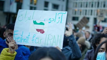 28.09.2022, Berlin: Teilnehmer demonstrieren mit Plakaten für Demokratie und Freiheit im Iran am Brandenburger Tor. Foto: Kay Nietfeld/dpa +++ dpa-Bildfunk +++