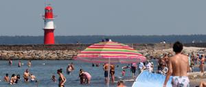 Badegäste genießen die Sonne am Ostseestrand. Am Wochenende meldet sich der Hochsommer mit entsprechenden Temperaturen zurück. 