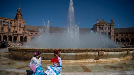 In Sevilla sitzen zwei Frauen vor einem Brunnen.