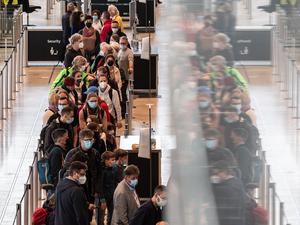 Dicht an dicht stehen Reisende am Flughafen BER vor einem Check-in-Schalter. 