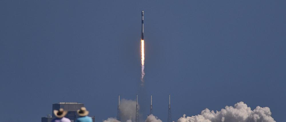 24.03.2023, USA, Merritt Island: Menschen beobachten den Start einer SpaceX Falcon 9-Rakete mit Starlink-Satelliten an Bord, die von der Cape Canaveral Space Force Station in Florida abhebt. Foto: Malcolm Denemark/Florida Today via AP/dpa +++ dpa-Bildfunk +++