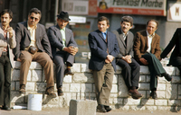 Gastarbeiter sitzen in der Sonne auf einer Mauer in Kreuzberg in den 1970er Jahren
