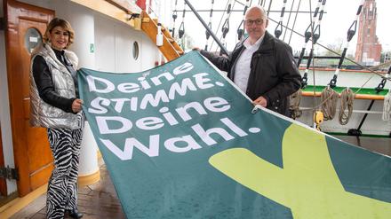 Sülmez Colak, bisher Vizepräsidentin der Bremischen Bürgerschaft, und Torsten von Haaren (SPD), Stadtverordnetenvorsteher Bremerhaven, halten eine Flagge mit der Aufschrift „Deine Stimme, deine Wahl“ auf dem Schulschiff Deutschland.
