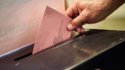 Ein Wähler wirft seinen ausgefüllten Wahlzettel in einem Wahllokal im Stadtteil Charlottenburg-Wilmersdorf in Berlin in eine Wahlurne.