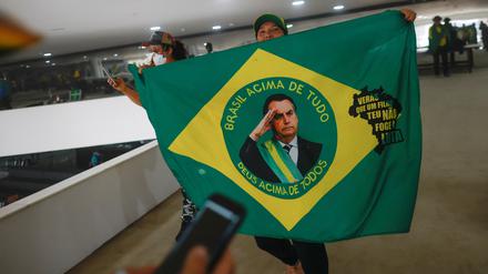 A supporter of Brazil's former President Jair Bolsonaro holds a flag depicting him during a demonstration against President Luiz Inacio Lula da Silva, in Brasilia, Brazil, January 8, 2023. REUTERS/Adriano Machado