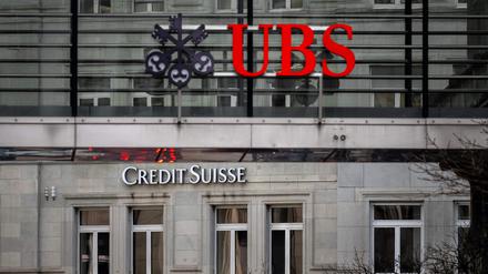 Nun Verknüpft – das Logo der „UBS“ auf einem Gitter vor einer Hauswand mit dem Schriftzug von „Credit Suisse“.