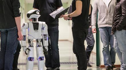 Symbolbild für den Forschungsbereich Robotik an der Berliner Hochschule für Technik (BHT). Im Bild Mitarbeitende und Studierende der BHT mit einem Myon-Roboter.