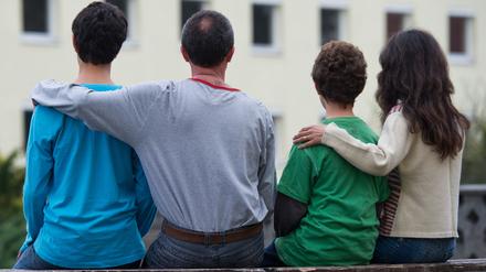 Eine syrische Familie sitzt vor einem Asylwohnheim der Zentralen Ausländerbehörde des Landes Brandenburg.