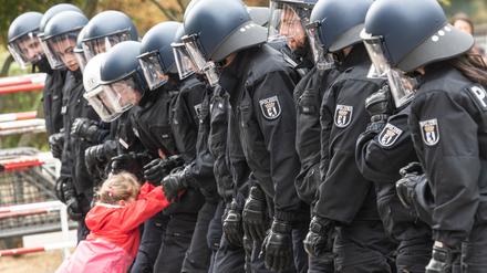Polizeischüler haben beim Tag der offenen Tür der Berliner Polizei eine Kette gebildet, wie sie bei Demonstrationen üblich ist. Ein Kind versucht nach Aufforderung, die Polizeikette zu durchbrechen. (Archivbild)