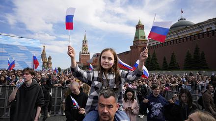 Tausende von Menschen schwenken russische Nationalfahnen, während sie sich auf dem Roten Platz versammeln, um ein Konzert zum Tag Russlands zu besuchen.