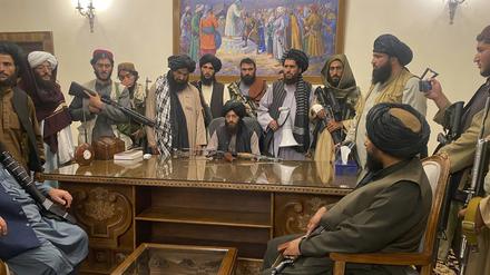 Taliban-Kämpfer sitzen in einem Raum des Präsidentenpalastes. 