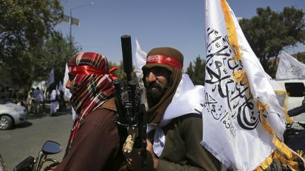 Taliban schwenken Fahnen.