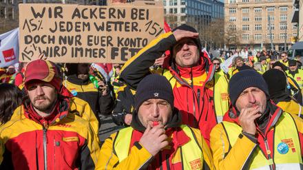Mit Plakaten demonstrieren Beschäftigte der Deutschen Post in Frankfurt am Main für eine Tariferhöhung von 15 Prozent.
