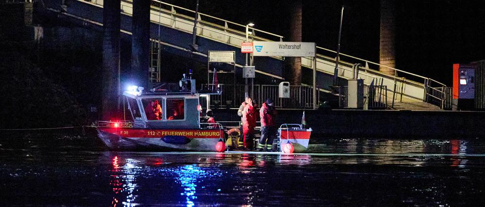 Feuerwehrleute stehen in der Nähe des Anlegers Waltershof auf einem Boot. In der Hamburger Elbe haben Taucher in der Nähe der Köhlbrandbrücke nach einem vermissten Menschen gesucht. 