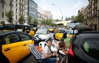 Taxifahrer blockieren mit Tischen und Stühlen die Gran Via in Barcelona, während sie an einem Streik teilnehmen. Aus Ärger über zu viele Lizenzvergaben an Konkurrenz-Unternehmen wie Uber und Cabify sind die Taxifahrer in einen unbefristeten Streik getreten.