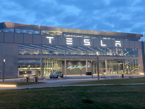 Der beleuchtete Schriftzug „Tesla“ am Werk, das jetzt wieder am Stromnetz ist.