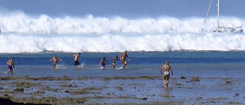 Die Tsunami-Welle rollt am 26. Dezember 2004 auf den Strand von Rai Lay im Süden Thailands zu. Eine schwedische Touristin läuft ihr entgegen, um ihre Familie zu warnen.
