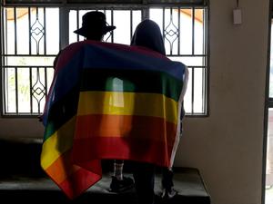 Ein ugandisches Paar bedeckt sich mit einer Pride-Fahne. 