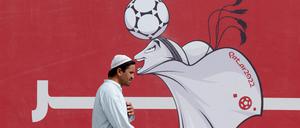 Ein Mann geht am offiziellen WM-Logo vorbei.