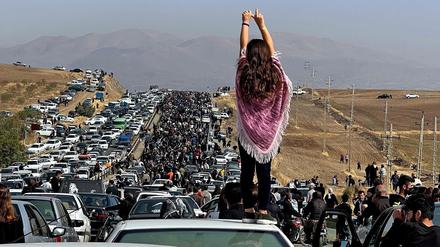 Eine Frau steht in Masha Jina Aminis Heimatstadt auf einem Autodach. Es ist der 40. Tag nach dem Tod der jungen Kurdin.