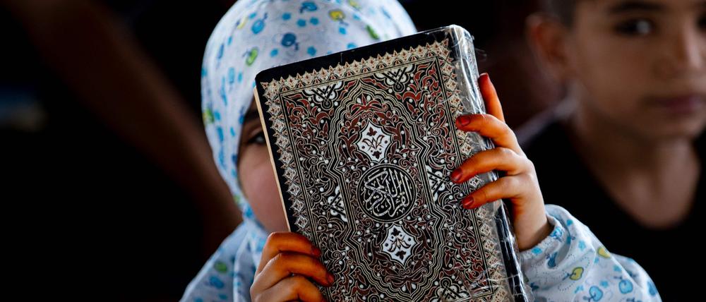 Eine Frau hält den Koran in den Händen.