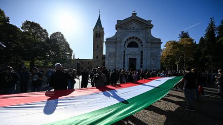 Eine italienische Flagge wird von Mussolini-Anhängern am Grab des Diktators getragen