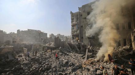Menschen durchsieben die schwelenden Trümmer von Gebäuden, die bei einem israelischen Angriff auf das Flüchtlingslager Bureij im zentralen Gazastreifen am 2. November 2023 zerstört wurden.